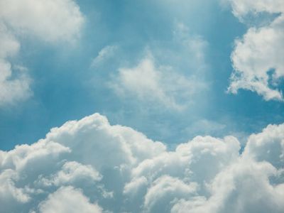 Blue sky with soft white clouds.